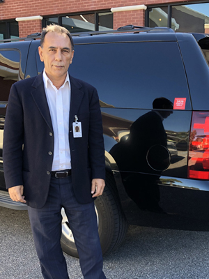Chauffeur in front of luxury SUV